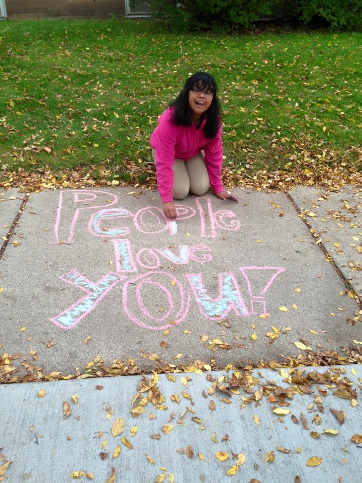 Student at Stonebridge School drawing with chalk on the sidewalk